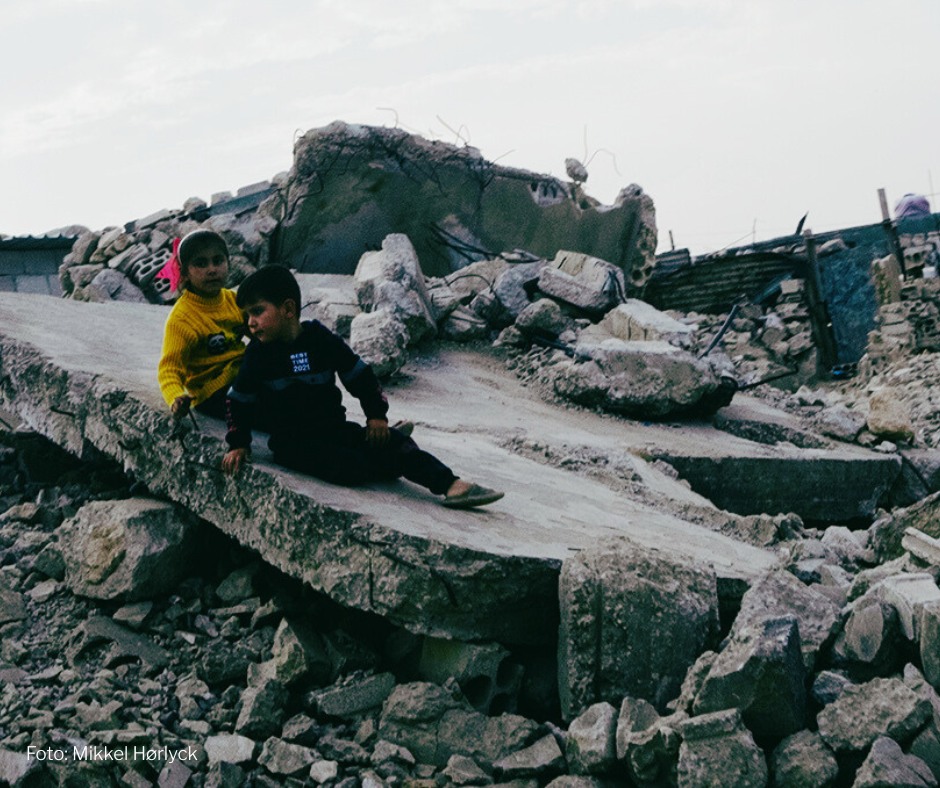 To børn leger midt i murbrokkerne i Syrien. To børn leger midt i murbrokkerne i Syrien.