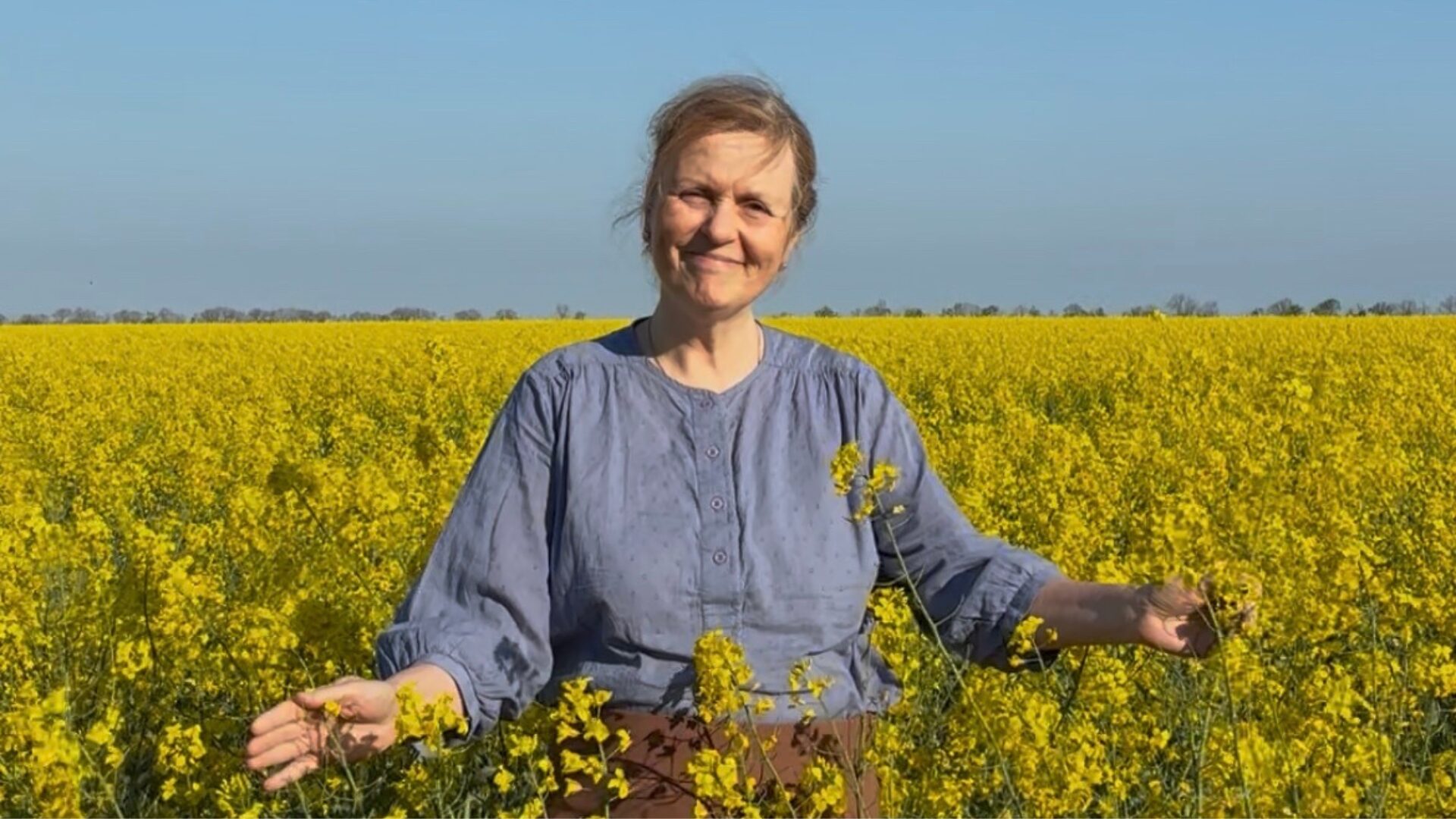 Betina Gollander-Jensen står i en gul mark med blå himmel under sit seneste besøg i Ukraine.