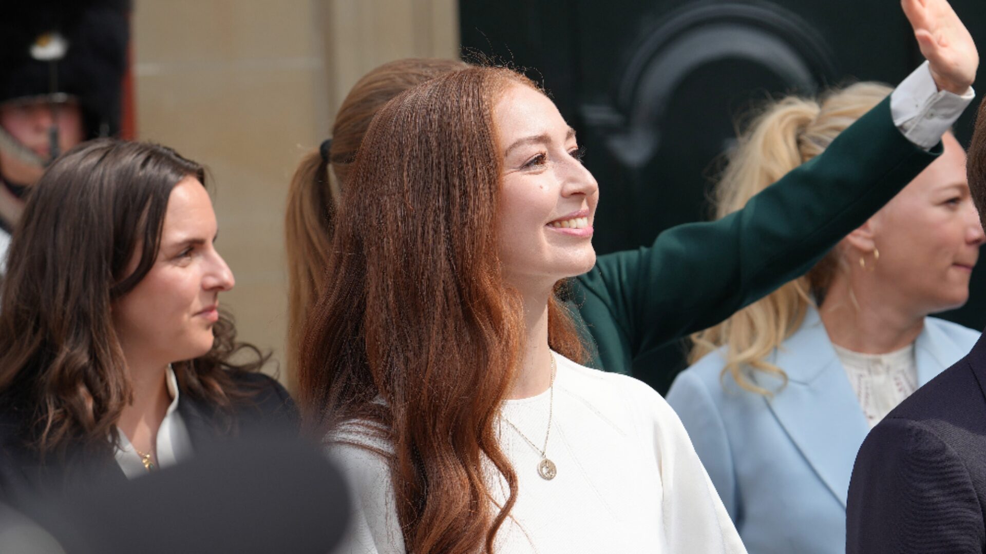 Samira Nawa står i menneskeflok i hvid kjole på dagen for sin indsættelse som Danmarks nye klimaminister.